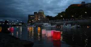 Les lanternes Tōrō nagashi déposées sur la rivière Ōta à Hiroshima, avec le dôme Genbaku en fond